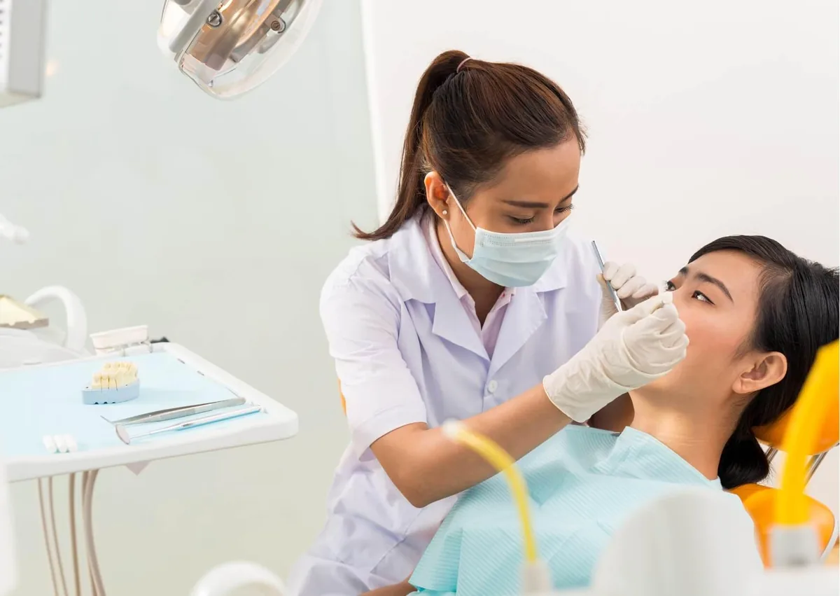 Dentist examining a patient after tooth extraction for signs of dry socket.
