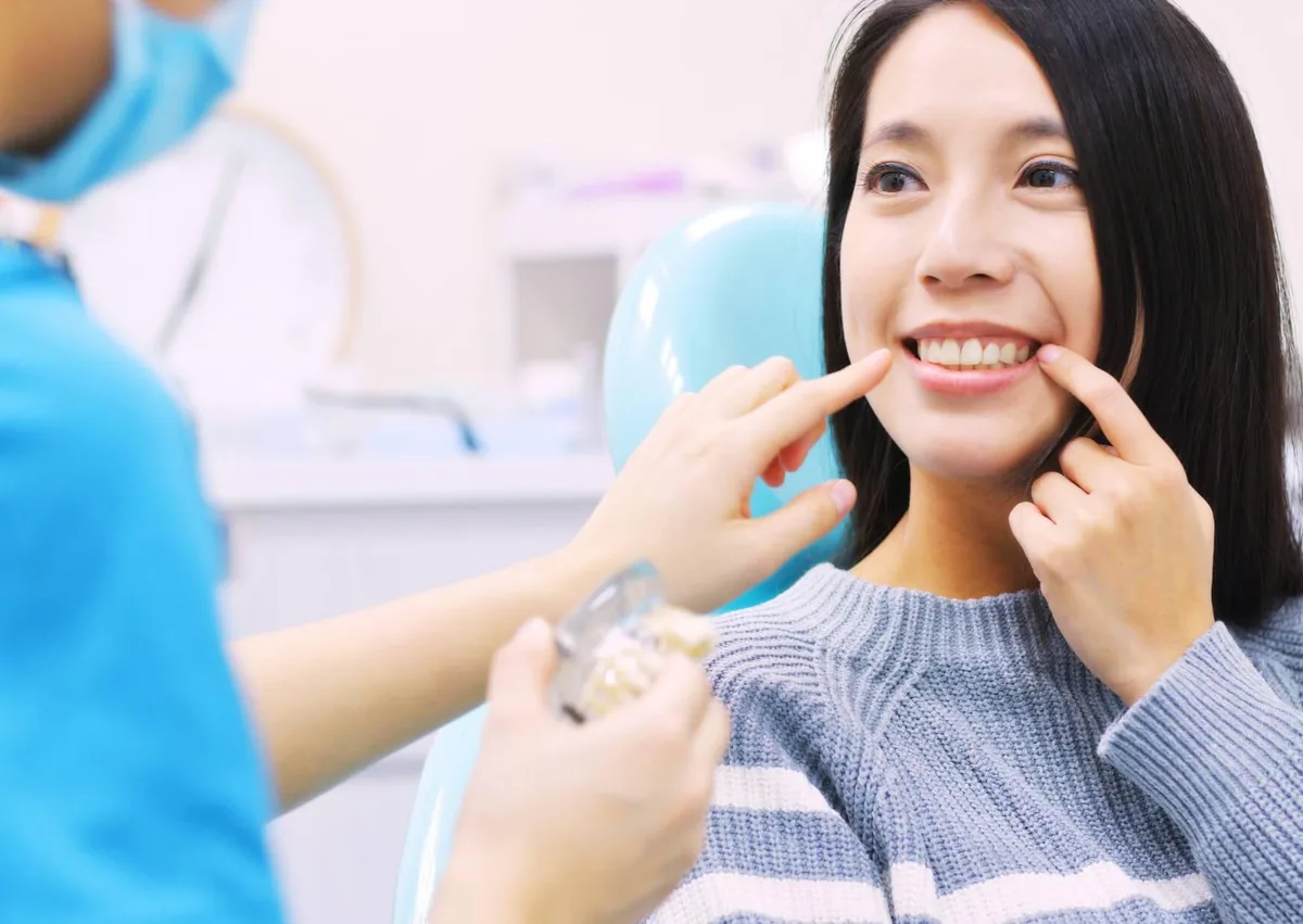 Patient discussing dentures and dental implants with a dental professional during a tooth replacement consultation.