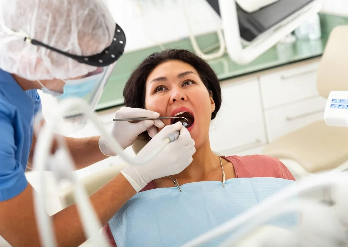 Dentist examining a patient experiencing persistent dry mouth and related oral health concerns.
