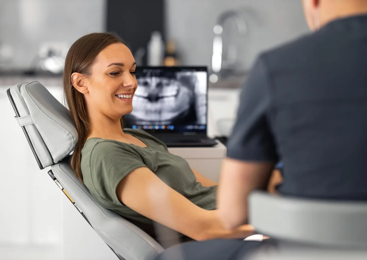 Smiling woman consulting with a dentist about teeth bonding treatment options and the cost of cosmetic dental bonding.